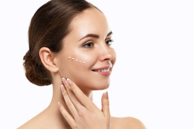 Güzel bir kadınla yüz kremi. Cilt koruma. Cilt Bakımı. Spa. Genç bir dişi tutan nemlendirici krem ve gülümseyerek. Doğal makyaj