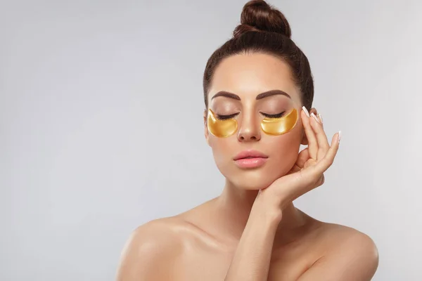 漂亮的女人面对着眼皮底下的胶原蛋白金垫 防老化保湿眼罩 金凝胶片 眼部皮肤治疗 — 图库照片