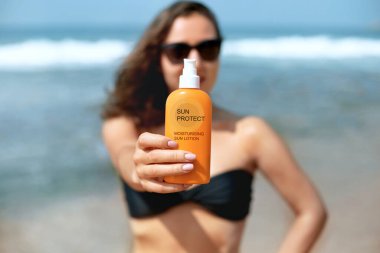 Woman Holding Suntan Lotion and Moisturizing Sunblock. Sun Protection. Sunscreen . Skin and Body Care. Girl Using Sunscreen to Skin. 