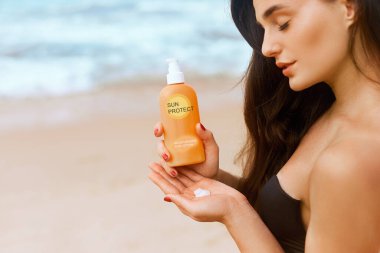 Şişeli Güneş Kremi Tutan Kadın. Nemlendirici losyon. Cilt bakımı. Güneş kremi