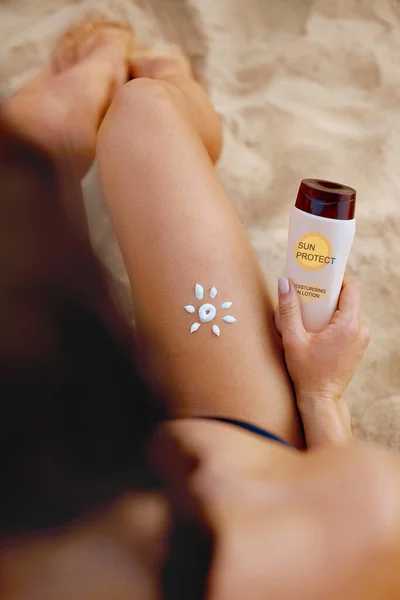 Woman With Sun Shape On The Leg. Sun Protection Sunscreen On Her Smooth Tanned Legs. Sunblock. Skin Care