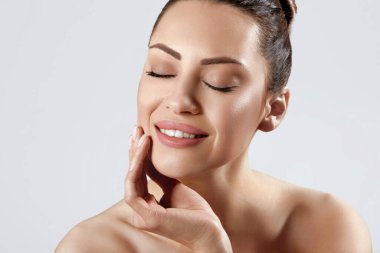 Temiz Taze Cilt Dokunuşlu Güzel Genç Kadın. Doğal makyajlı, gülümseyen kız modeli, yüz bakımı. Kozmetik, güzellik ve kaplıca .