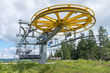 Spinning wheel with electric cable hoist motor in a ski resort in summer