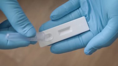Doktorun elinde COVID-19 koronavirüs üzerinde pozitif antijen testi