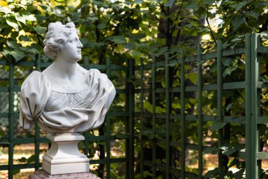 Şehirli Yunan ya da İtalyan Rönesans döneminin heykeli Şehir parkındaki çiçekli kadın Altın Sonbahar renklerine büründü,