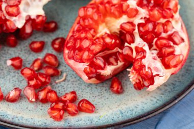 Masanın üzerinde mavi bir arkaplanda olgun bir nar.