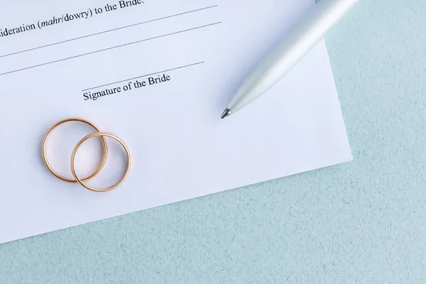 与一对结婚戒指签署婚约形式的协议 — 图库照片
