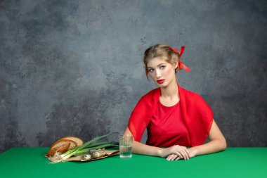 Ekmek ve yeşil soğanla birlikte masadaki genç kız. Çok parlak görüntüler. 