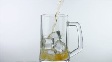 Büyük buz küpleriyle şeffaf bir kokteyl bardağına bira dökmek. Büyük bardakta soğuk bira, beyaz bir arka planda. Parti zamanı, kutlamalar, akşamdan kalma, sarhoş.