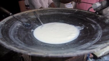 Saf süt büyük bir Tawa 'da ısıtılıyor / kaynatılıyor ve büyük bir sürahiye dökülüyor. Eski Delhi 'de küçük bir dükkan, Chandni Chowk müşterilerine sıcak süt veriyor. 