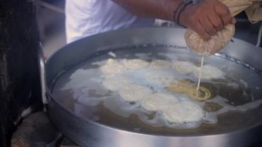 Yol kenarındaki bir dükkanda sıcak Jalebis yapan bir adam, Hint tatlıları. Chandni Chowk 'ta ünlü bir Jalebiwala, Eski Delhi, Hindistan - popüler sokak yemekleri, geleneksel tatlılar