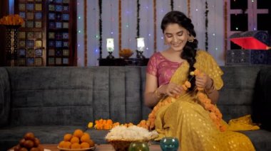 Diwali süslemeleri- güzel bayan / bayan taze çiçeklerle çelenk yapıyor. Cazip Gulab Jaamuns ve Laddus Hint festivali için bir tabakta servis yaptılar. Bayram sezonu, Hindu festivali, Deepavali