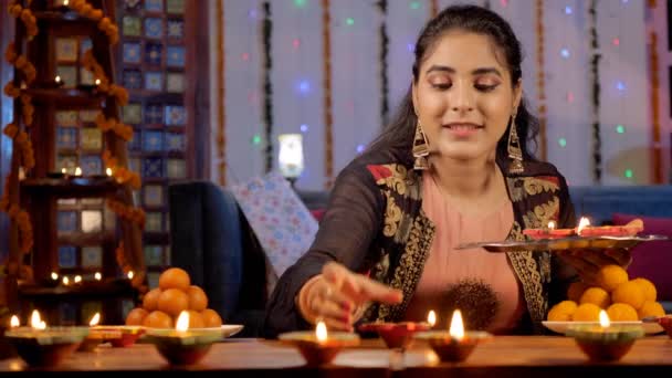 Una Mujer Bonita Que Mantiene Brillantemente Quemando Diyas Una Mesa — Vídeos de Stock