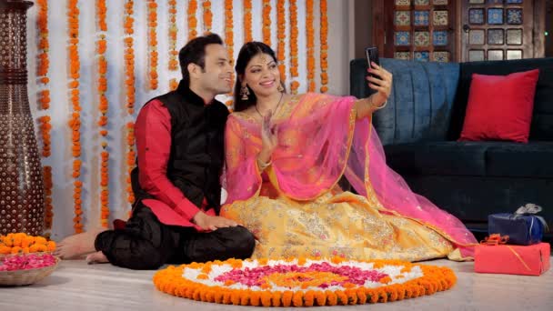 在Diwali期间 一对已婚夫妇愉快地在视频通话中挥手聊天 传统上在客厅里做兰戈里和五颜六色的礼物 Diwali装饰品 一个印度教节日 节日期间 — 图库视频影像