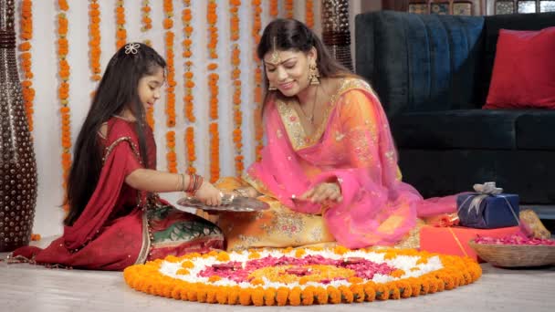 ディヤと伝統的なランゴリを飾る愛する母親と娘 美しい女性と彼女の女の子の子供は ディワリのお祝いのために家を飾る中で床に座っています ヒンズー教の祭り お祝いの背景 家族関係 — ストック動画