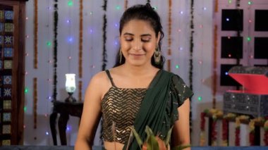 Diwali vesilesiyle elinde Kalaşla Puja Thaali tutan çekici bir kadın. Geleneksel Saree 'de güzel bir kadın fotoğraf makinesi için mutlu poz veriyor. Bayram sezonu, Hint kültürü, uğurlu bir olay, bir Hindu festivali.