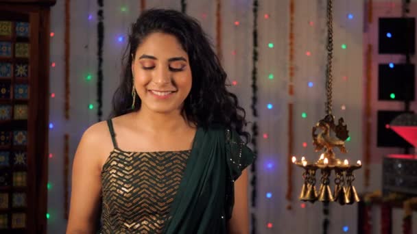 一个快乐的女人拿着一盘粘土迪亚斯站在那里庆祝Diwali 在喜庆的背景下 一位身穿民族服装的漂亮女性在镜头前快乐地摆姿势 一个印度教节日 一个吉祥的场合 一个印度文化 — 图库视频影像