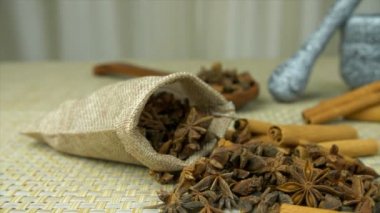 Egzotik baharat yıldızı anason topçu çantasından düşüyor ve tarçın bir arada tutuluyor. Hint baharat yıldızı anason ve havan topuzu jüt bir hasırın üzerinde bir arada tutulur. Yemek malzemeleri, aromatik, lezzetli yemekler.