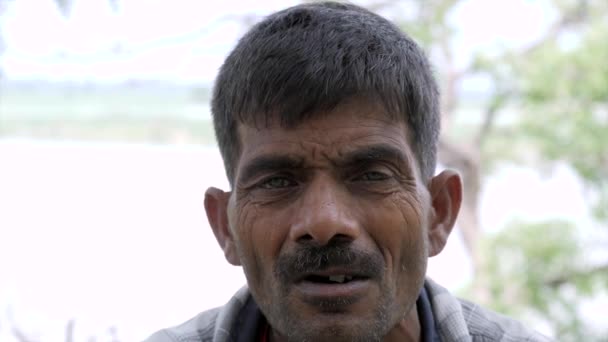 一个印度穷苦的村民喜欢在业余时间抽蜂窝 村里的一个中年男子 穿着印有甜菜和烟叶的衣服 — 图库视频影像