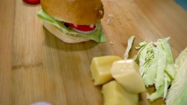 Evde hazırlanmış lezzetli vejetaryen burger, ıvır zıvır yemek, sabah kahvaltısı. Yakın plan domates, yeşil lahana, peynir ve soğan halkaları.