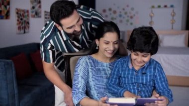 Zeki bir genç çocuk ve sevimli neşeli annesi birlikte kitap okuyorlar. Eşi ve oğluyla vakit geçiren şefkatli bir koca - boş zaman, aile babası, ebeveynlik becerileri, mutlu çocukluk, aile bağı, nükleer aile