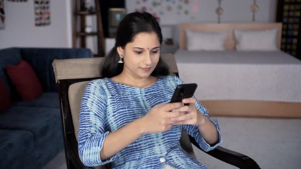 Una Joven Madre India Feliz Usando Teléfono Inteligente Sentado Una — Vídeo de stock