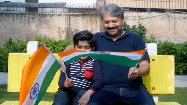 인도의 할아버지와 손자가 국기를 흔들었습니다 의어린 공원에서 벤치에 즐거운 시간을 — 비디오