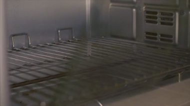 Hintli bir ev kadını fırında kek / kek pişiriyor. Yemek pişirmek için mutfağa önceden ısıtılmış bir fırın. Modern bir alet, fırın, lezzetli yemekler, yaşam tarzı.