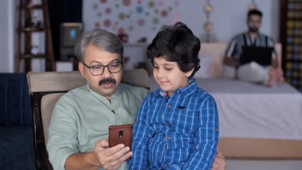 Yaşlı Bir Adam Genç Torunu Evde Birlikte Akıllı Telefon Kullanıyorlar — Stok video