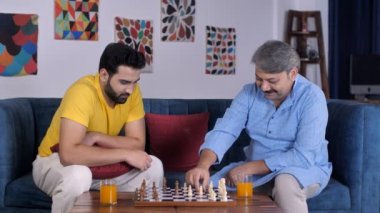 Orta yaşlı bir oğul ve yaşlı bir adam birlikte satranç oynuyorlar. Kaliteli bir aile zamanı, baba-oğul bağı. 30 'lu yaşlarda çekici bir erkek babasıyla masa oyunu oynarken konsantre oluyor. Strateji planı, öngörü becerileri....