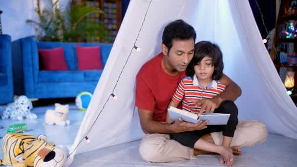 Ein Gutaussehender Vater Und Sein Entzückender Sohn Lesen Gemeinsam Ein — Stockvideo