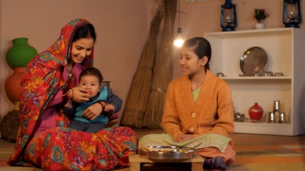 彼女の伝統的なキッチンで彼女の家族のための料理の食事を見て農村主婦 余暇に妹と遊んでいる若い女の子 インドの村のシーン 幸せな家族 関係と絆 家族のケア — ストック動画