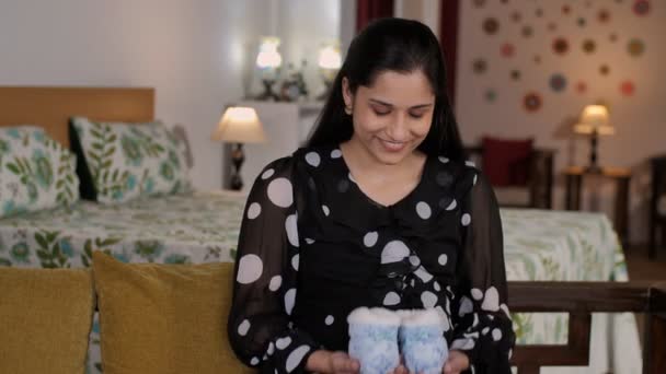 Una Joven Embarazada Con Una Gran Barriga Sosteniendo Botas Azules — Vídeo de stock