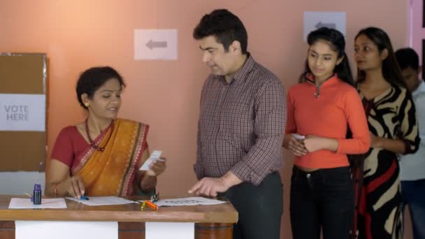 Egy Középkorú Választási Tiszt Kék Tintával Jelöli Meg Választópolgár Ujjait — Stock videók