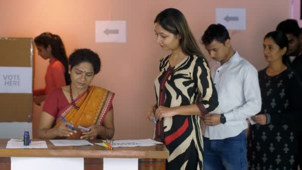 チュナアフ アドヒカリは 投票用紙と投票者の身元証明 インドの議会選挙 州の選挙 をチェックします 投票ブースで投票する順番を待っている人々 投票センター 自治体選挙 投票権 — ストック動画