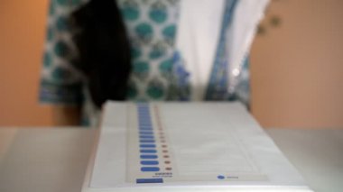 Bir düğmeye basarak oy kullanma hakkını kullanan sıradan giyinmiş genç bir üniversiteli kız. Temel bir hak, demokratik bir ülke. Bir oy kullanma merkezinde elektronik oylama makinesi. Oy kullanma merkezleri, belediye seçimleri, kayıtlı bir seçmen....