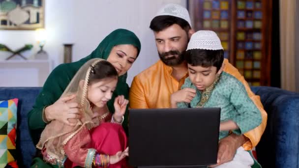 インドの核イスラム教徒の家族 民族衣装のかわいい兄弟 ラップトップを一緒に使用して陽気なイスラム教徒の家族 近代的な技術 電子ガジェット インターネット接続 — ストック動画