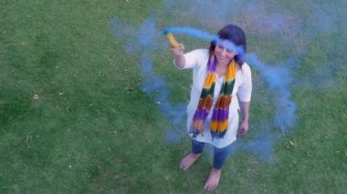Holi kutlaması için renkli duman çubukları kullanan neşeli bir bayan. Tehlikeli, havai fişekler, patlayacak. Geleneksel giyinmiş güzel bir kadın renk festivalini kutlarken - bir Hint festivali, bir uğurlu....