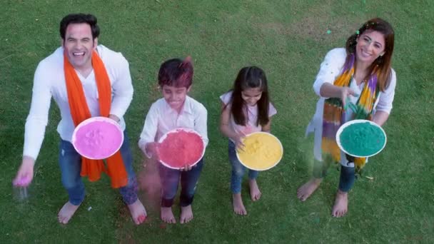 Young Couple Little Kids Throwing Colors Air While Playing Holi — Stock Video