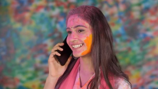 インドで幸せなホリを望む美しい女の子 色の祭りを呼び出します 幸せなホリを親戚に望むインドの若者と魅力的な女性 — ストック動画