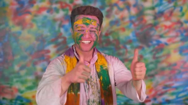 색채의 환호성을 지르며 포즈를 취하는 미소짓는 남자의 행복하고 축제를 원하는 — 비디오