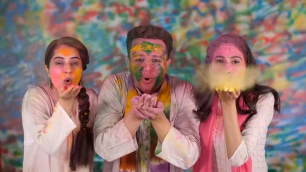 ホリを祝い 空気中の有機的な色を吹いている3人の若者 楽しさ 乾燥した色 文化を祝うインドの人々 インディアンによって祝われる色の祭り パーティー ハンサムな男の子 美しい顔 — ストック動画