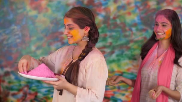 Индийская Сестра Празднует Холи Нанося Цвет Щеки Традиция Улыбающиеся Лица — стоковое видео