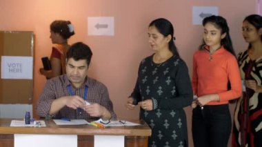 Bir erkek hükümet memuru tüm seçmenlerin parmaklarına mavi mürekkep işareti koyuyor. Hint vatandaşları, demokrasi, seçim kabini, Hindistan 'da oy kullanma. Kadın adaylar yerel bir oy kullanma kabininde oy veriyorlar - belediye seçimleri, oy kullanma hakkı, ...