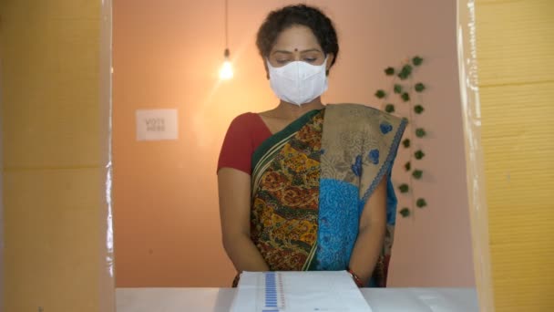 一位中年妇女戴着医疗面罩在投票站投票 验尸官大流行 社会疏远 一个在传统的Saree中投票的女性选民在投票后做了一个竖起大拇指的动作 一个基本的权利 民主人士 — 图库视频影像