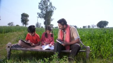 Kızılderili köyünden yakışıklı bir adam, tarlasında küçük çocukları var. Pirinç / hardal tarlası, Hindistan tarımı.