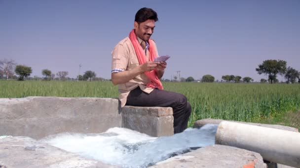 Ein Fröhlicher Indischer Bauer Der Der Nähe Eines Brunnens Geld — Stockvideo