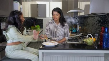 Sevecen bir Hintli anne küçük kızına sağlıklı bir yemek yediriyor. Lezzetli yemekler, ebeveyn-çocuk bağı. Mutsuz küçük bir kız kahvaltısını / öğle yemeğini yemeyi reddediyor - seçici, öfke nöbeti, yeme bozukluğu