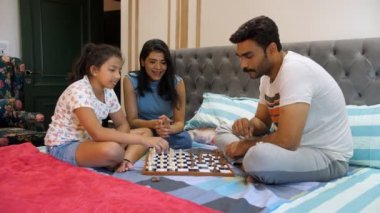 Genç bir nükleer aile birlikte satranç oynuyor. Masa oyunu, Hint ailesi, kaynaşma. Genç bir Hintli kız babasını bir satranç oyununda yendi. Rekabetçi bir oyun, stratejik hareketler.
