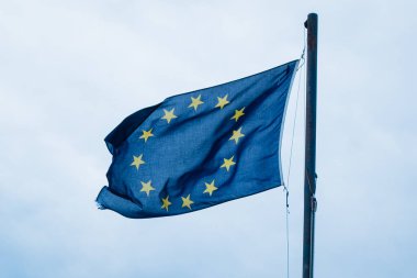 Gökyüzü arka planında AB bayrağı. Avrupa Birliği bayrağı rüzgarda dalgalanıyor. 